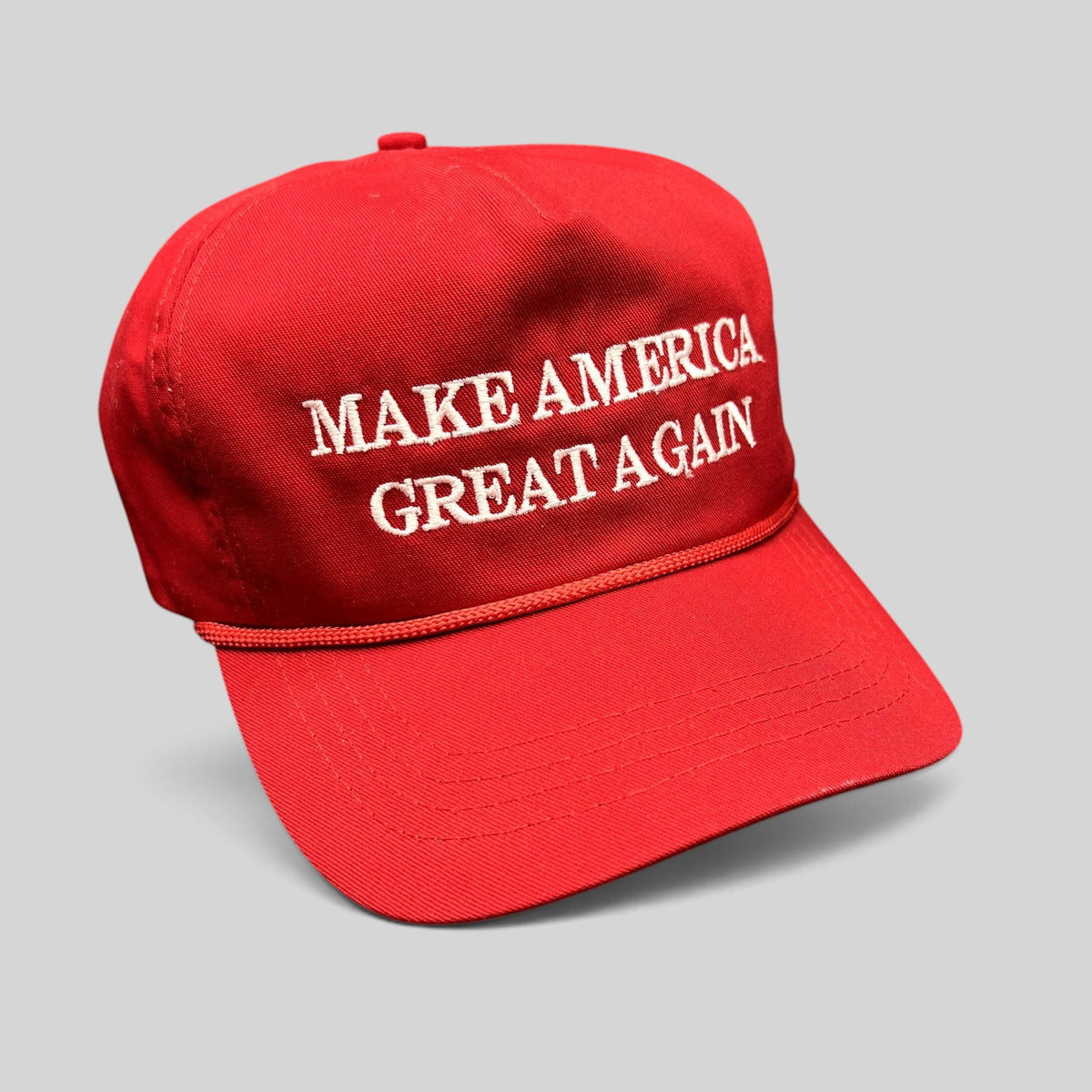 Raree Finds official red MAGA snapback hat with white embroidered text and braided rope detail.