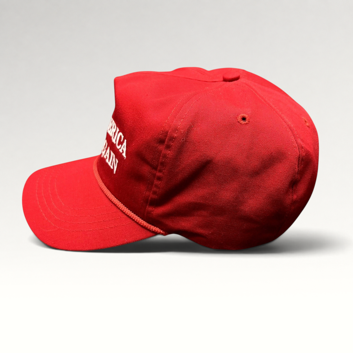 Raree Finds red Cali-Fame MAGA snapback hat with white embroidered text and braided rope detail, side profile view.