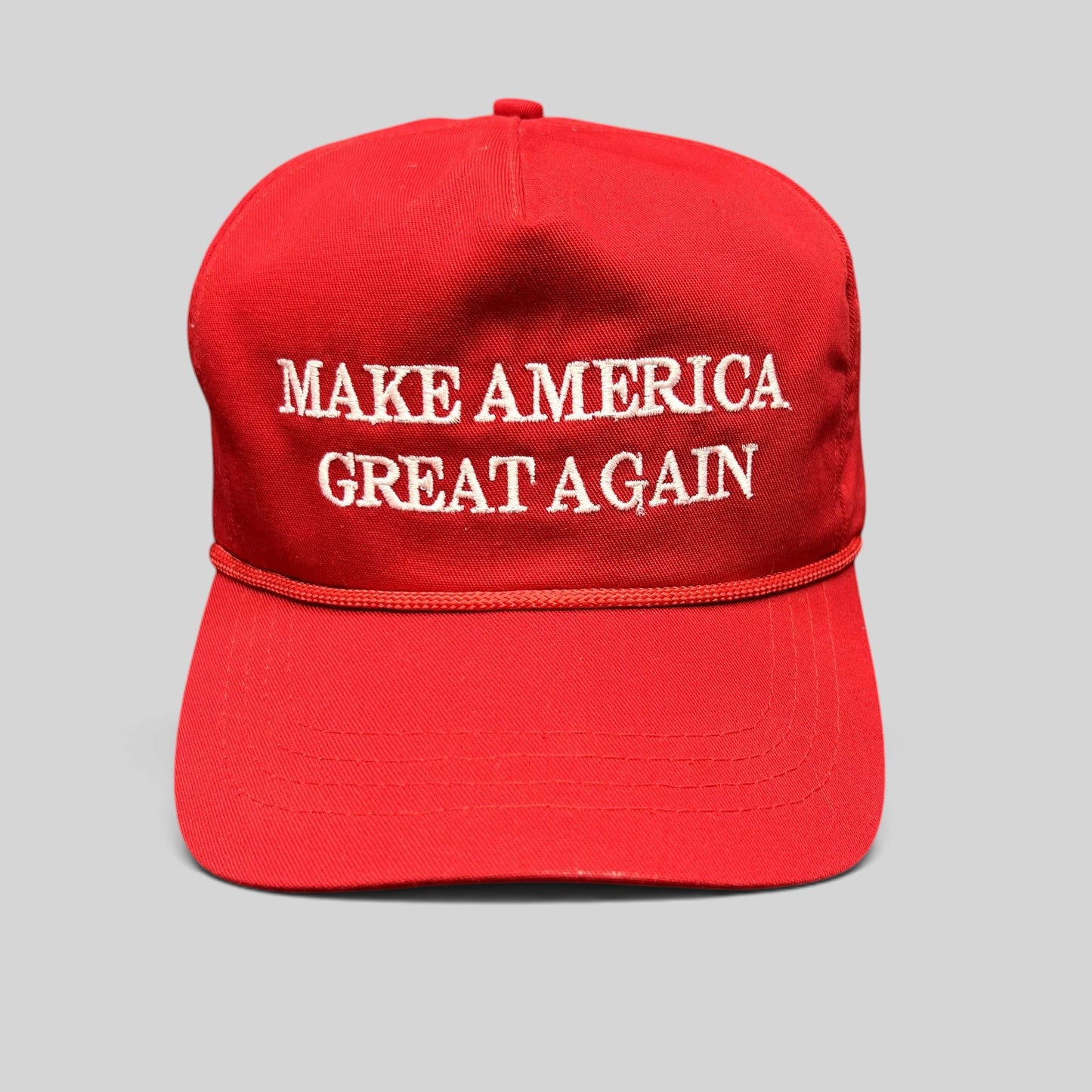 Raree Finds official red MAGA snapback hat with white embroidered lettering and braided rope detail.