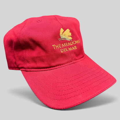 Raree Finds red cotton twill strapback golf cap featuring The Meadows Del Mar embroidered golden flower logo