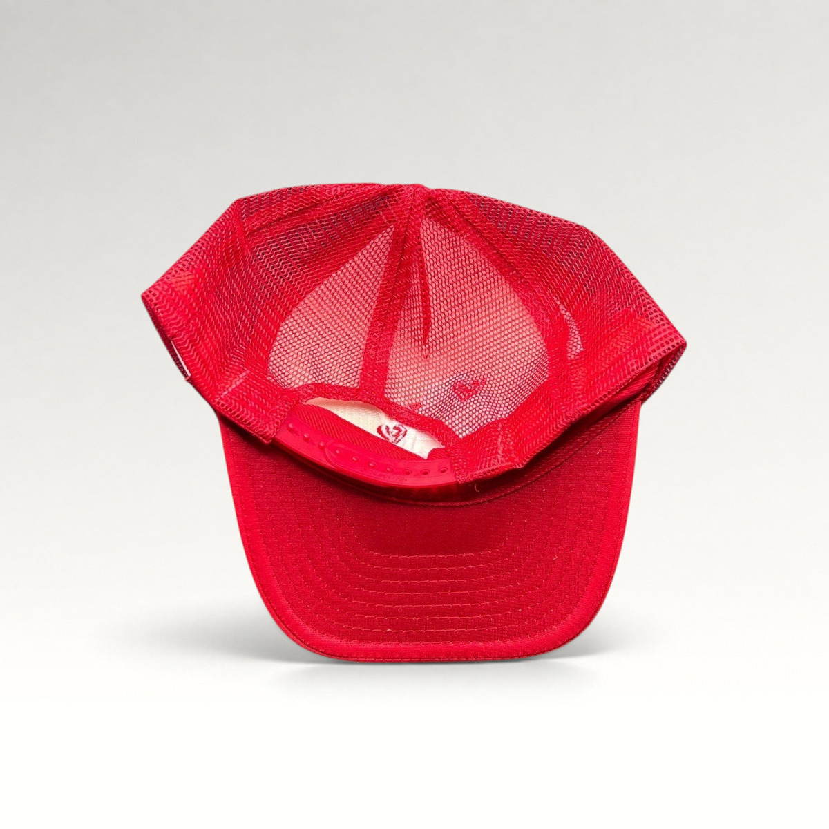Raree Finds red Nissin Cap trucker hat with breathable mesh back and adjustable snapback closure, top-down view.