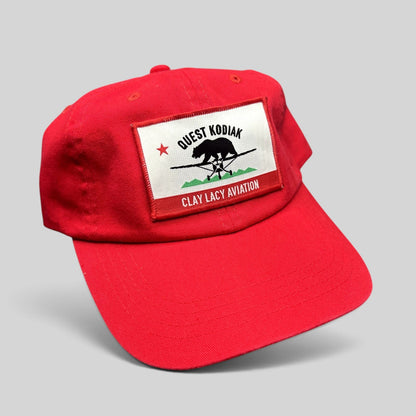 Raree Finds bright red cotton strapback hat featuring a woven Quest Kodiak and Clay Lacy Aviation aircraft patch