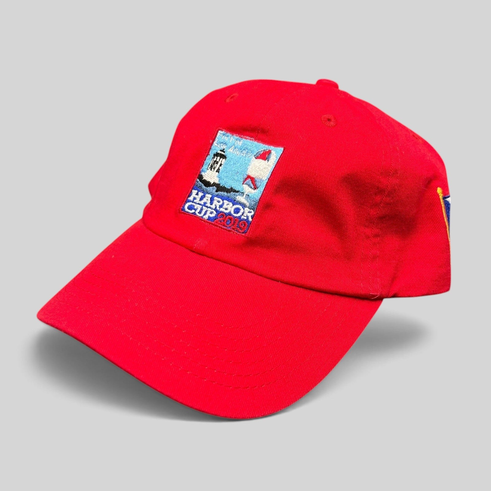 Raree Finds red cotton strapback hat featuring an embroidered Los Angeles Yacht Club Harbor Cup 2019 lighthouse patch