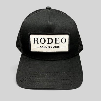Raree Finds black Rodeo Country Club trucker hat with a white embroidered patch and breathable mesh back panels.