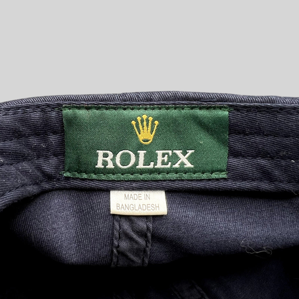 Raree Finds vintage navy blue sailing hat interior featuring a green Rolex brand tag and Made in Bangladesh label