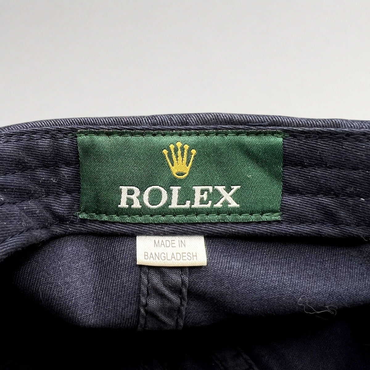 Raree Finds vintage navy blue sailing hat interior featuring a green Rolex brand tag and Made in Bangladesh label