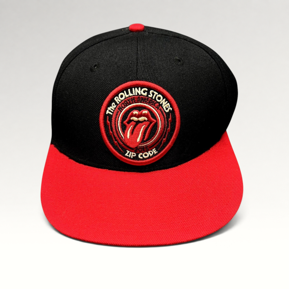 Raree Finds The Rolling Stones Zip Code 2015 tour snapback hat with black crown, red brim, and embroidered logo patch.