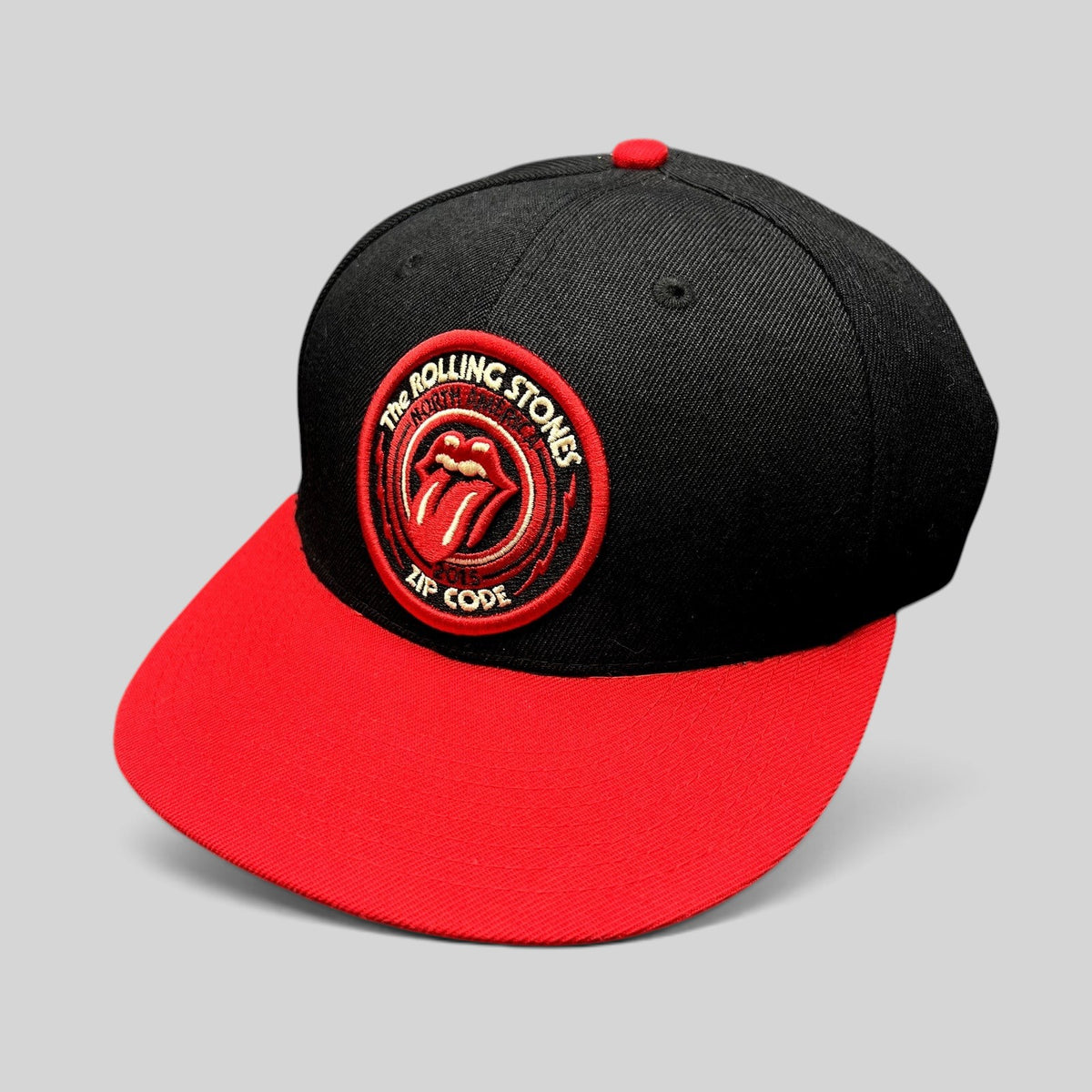Raree Finds The Rolling Stones Zip Code 2015 tour snapback hat with black crown, red brim, and embroidered logo patch.