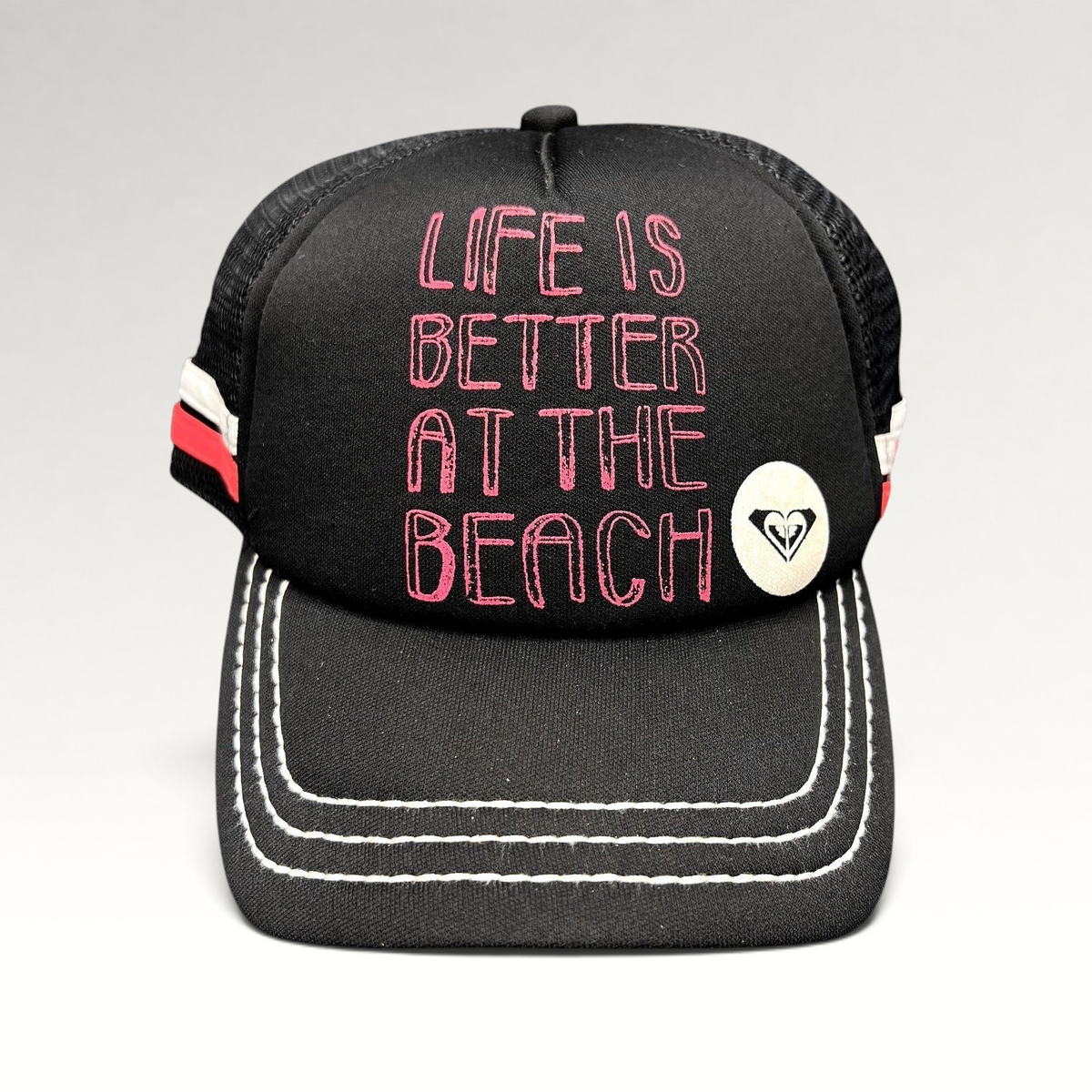 Raree Finds Roxy black trucker hat with pink Life Is Better At The Beach embroidery and white contrast brim stitching