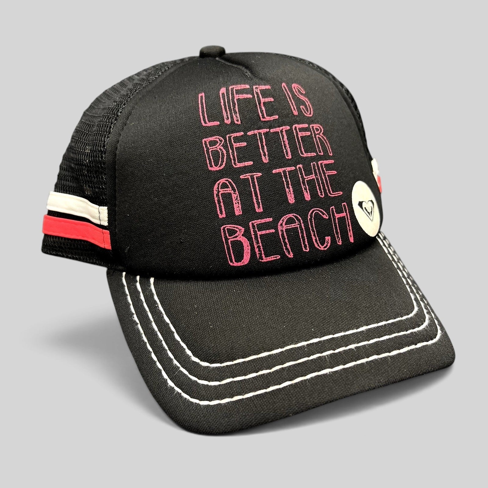 Raree Finds Roxy black trucker hat with pink Life Is Better At The Beach embroidery and white contrast brim stitching