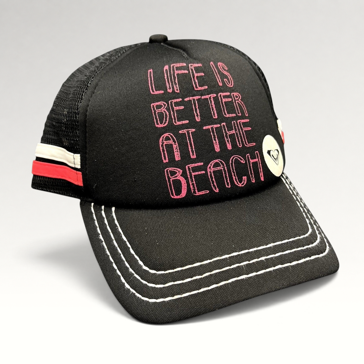 Raree Finds Roxy black trucker hat with pink Life Is Better At The Beach embroidery and white contrast brim stitching