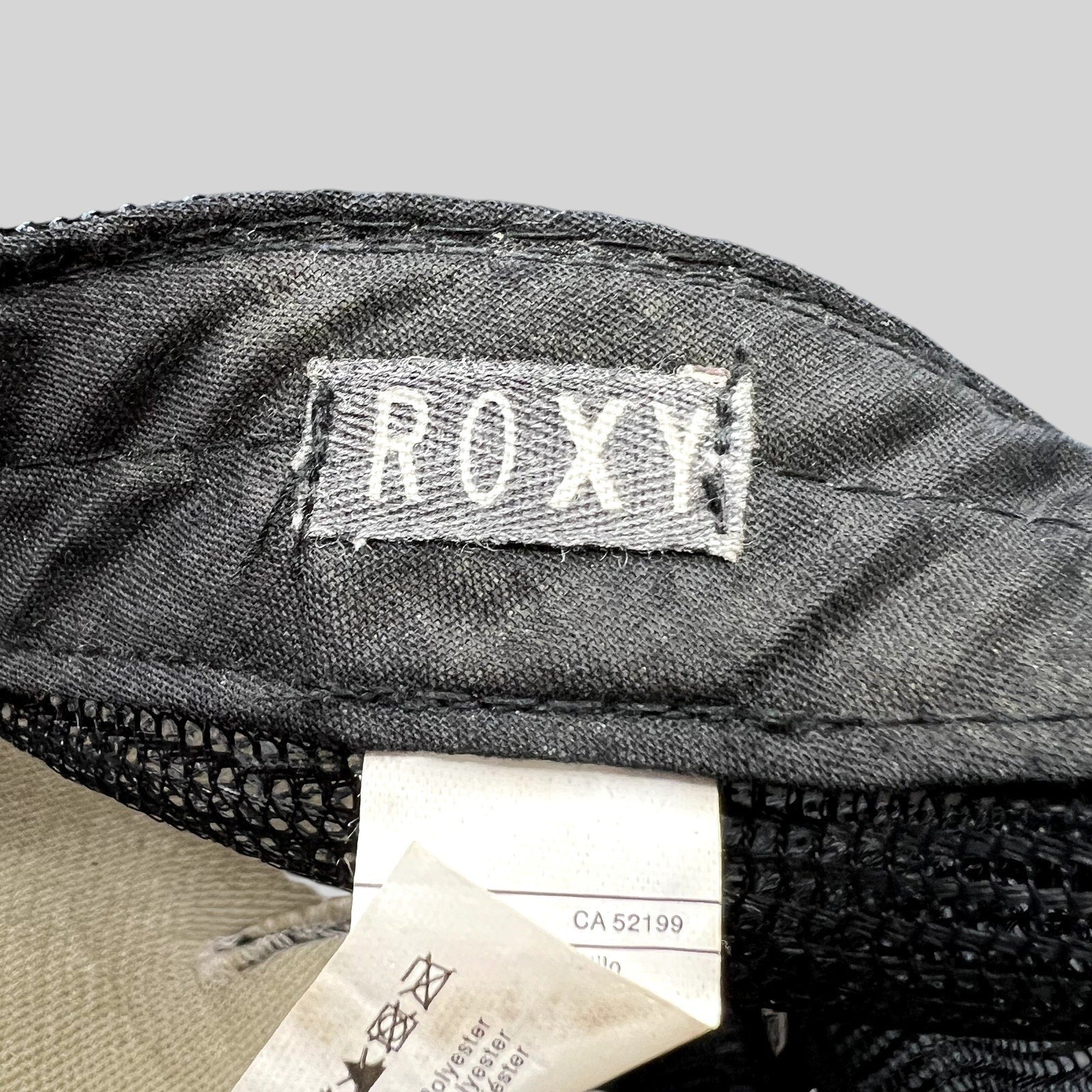 Raree Finds Roxy trucker hat interior label showing brand logo and care tag details on black mesh fabric