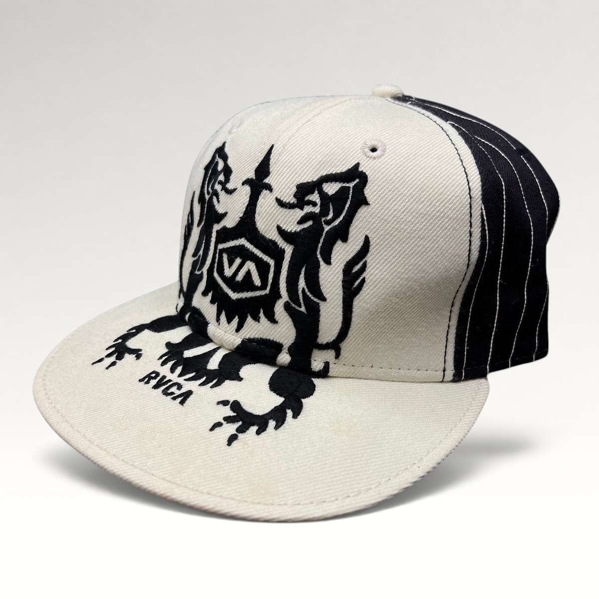 Raree Finds RVCA Y2K black and white wool blend snapback hat with a bold crest graphic on the crown and flat bill