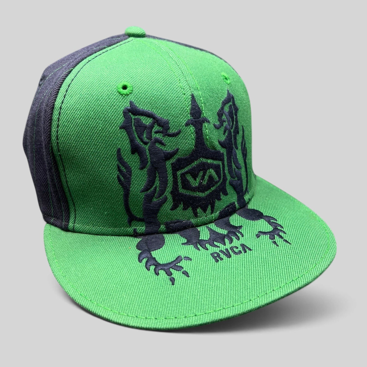 Raree Finds vintage green and black RVCA snapback hat featuring a gothic lion crest logo and flat brim