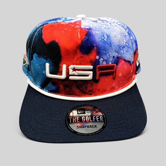 Raree Finds 2023 Ryder Cup Team USA snapback hat with red, white, and blue watercolor crown and navy brim.