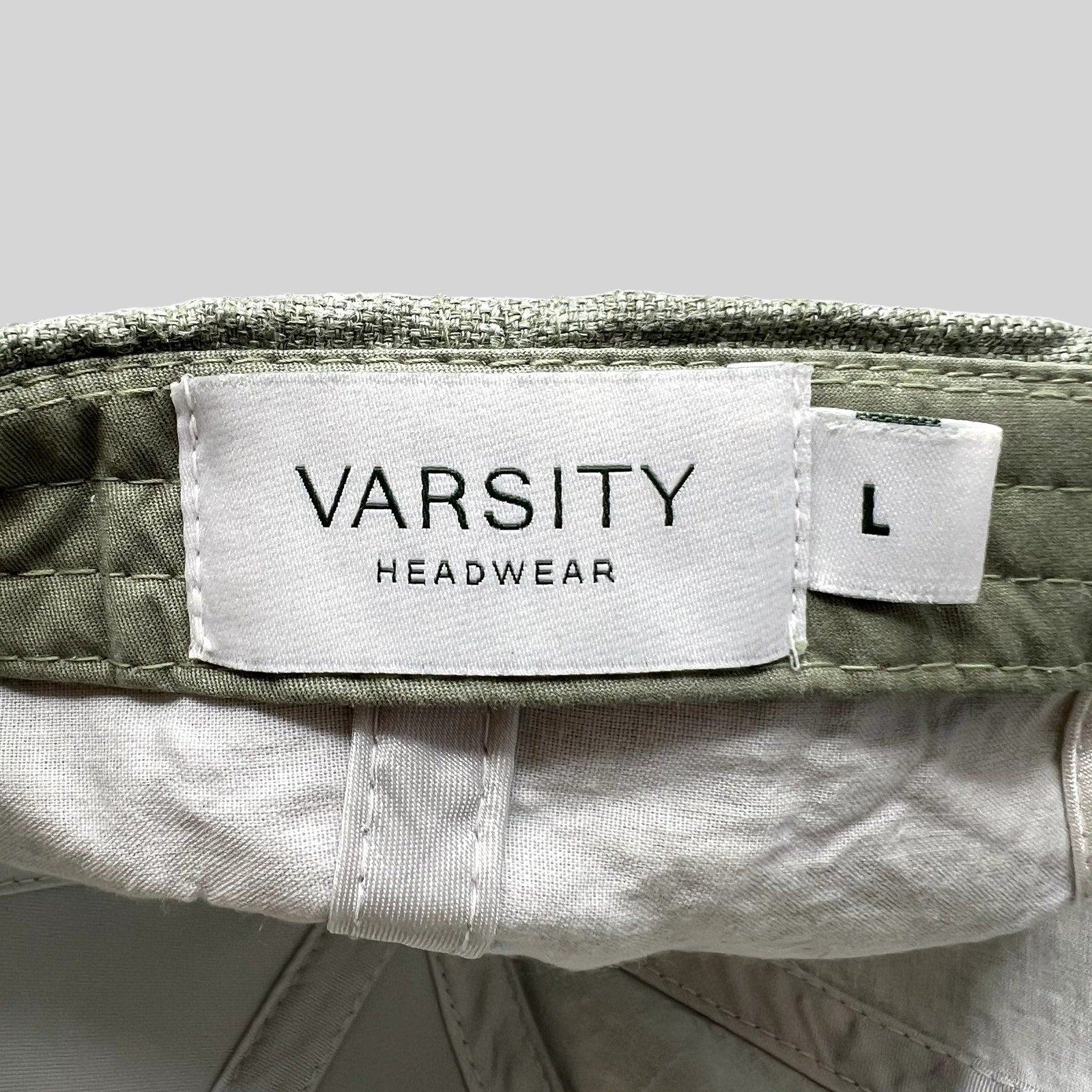 Raree Finds sage green linen cap interior label showing Varsity Headwear branding and size large tag