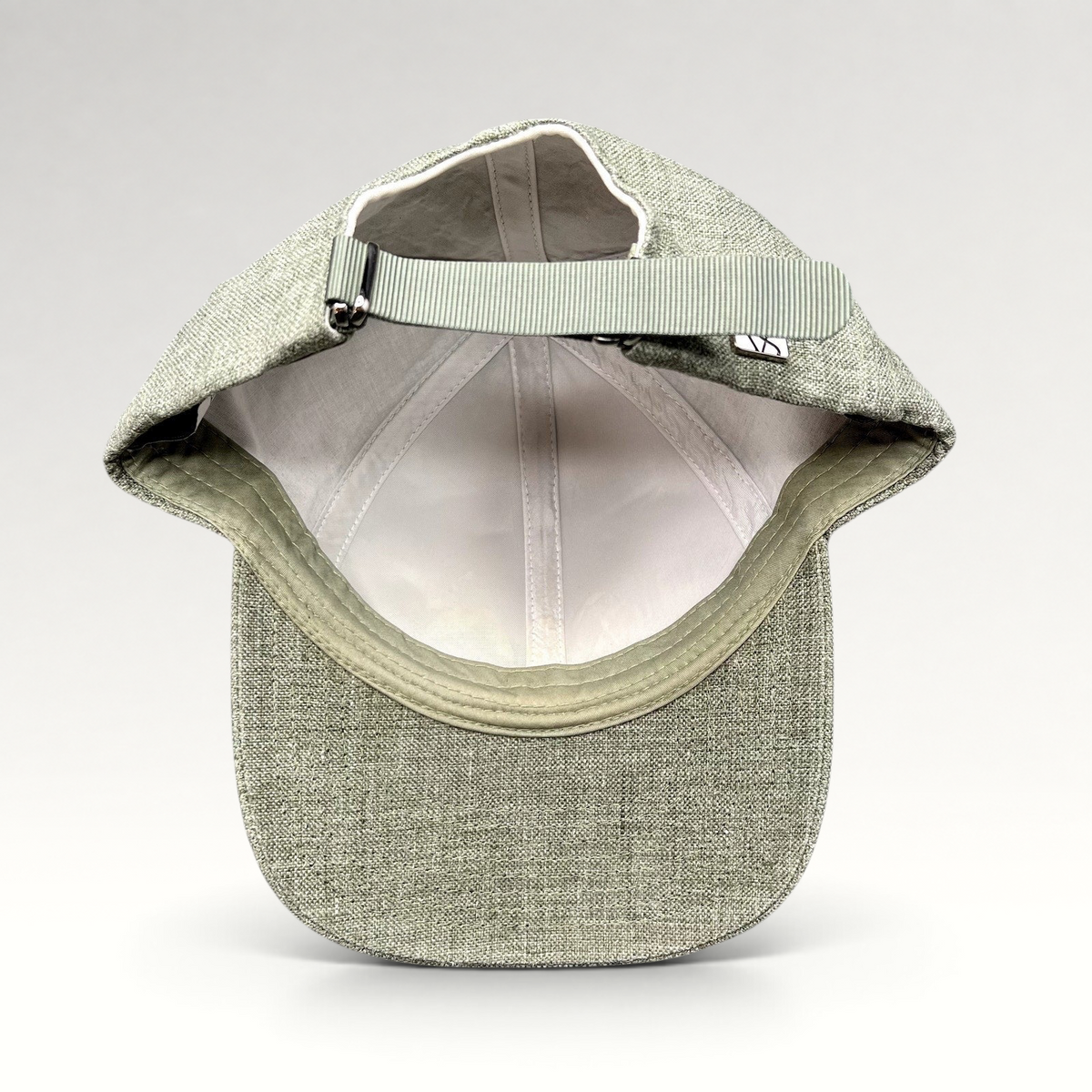 Raree Finds sage green Angelico Italian linen strapback cap with adjustable metal hardware and unstructured profile.