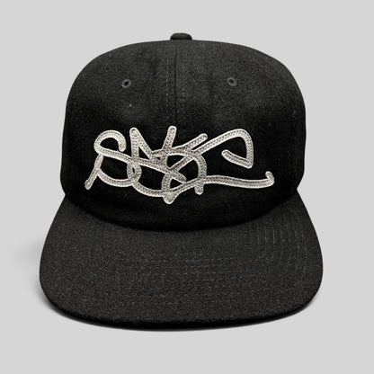Raree Finds Sake Brand black strapback cap with oversized gray embroidered script logo on a structured wool-blend hat.