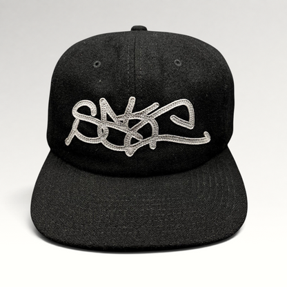 Raree Finds Sake Brand black strapback cap with oversized gray embroidered script logo on a structured wool-blend hat.