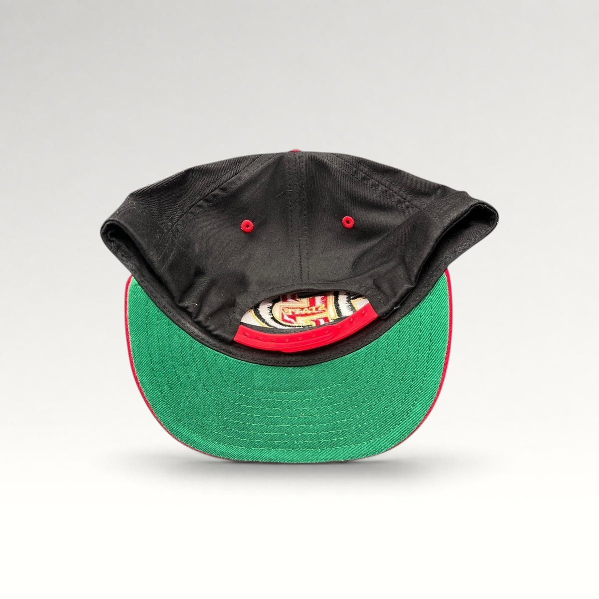 Raree Finds vintage San Diego State Aztecs snapback hat showing the green undervisor and red adjustable snap closure.