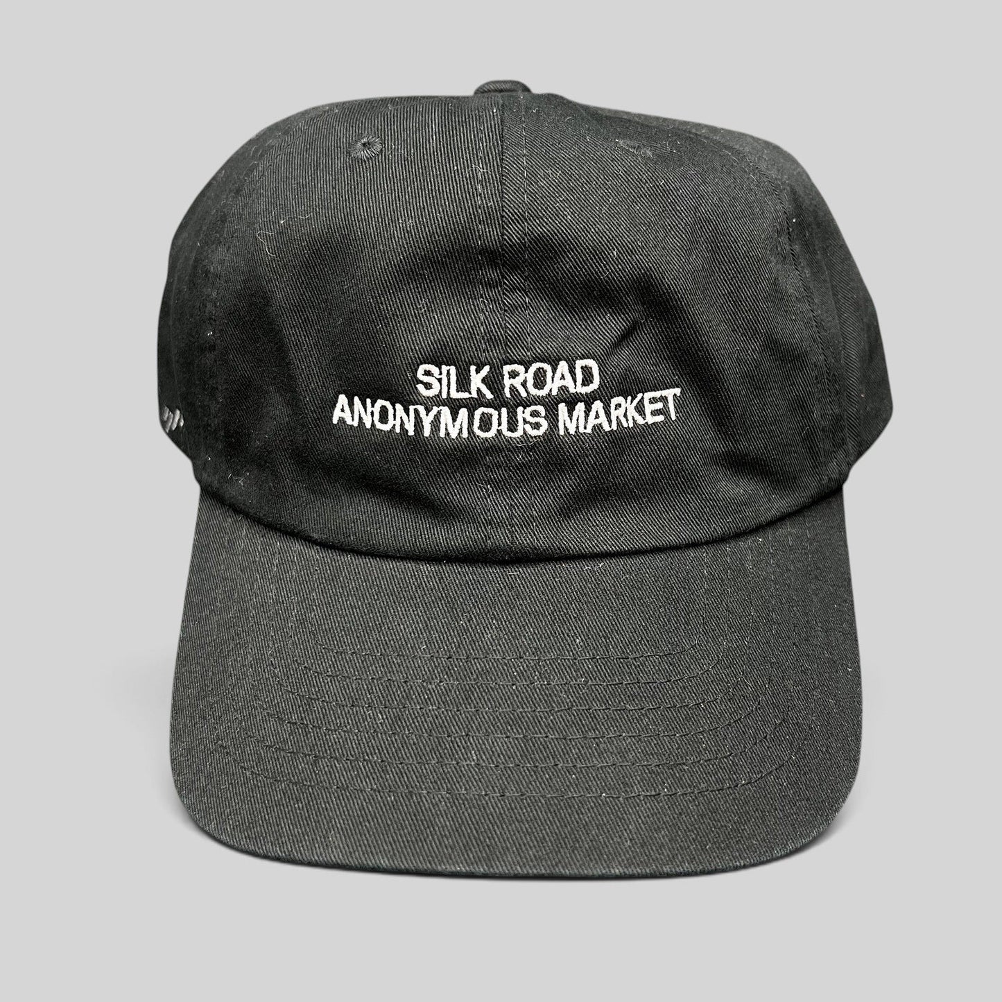 Raree Finds black Yupoong dad cap with white Silk Road Anonymous Market embroidery on the unstructured cotton crown.