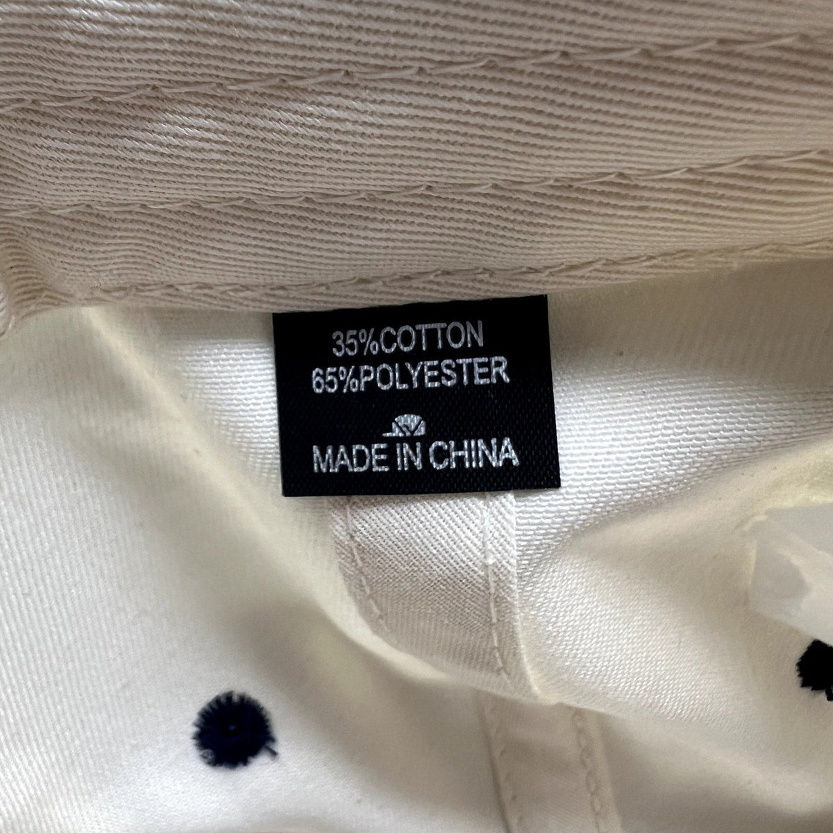 Raree Finds snapback hat interior fabric care label showing 35 percent cotton and 65 percent polyester composition