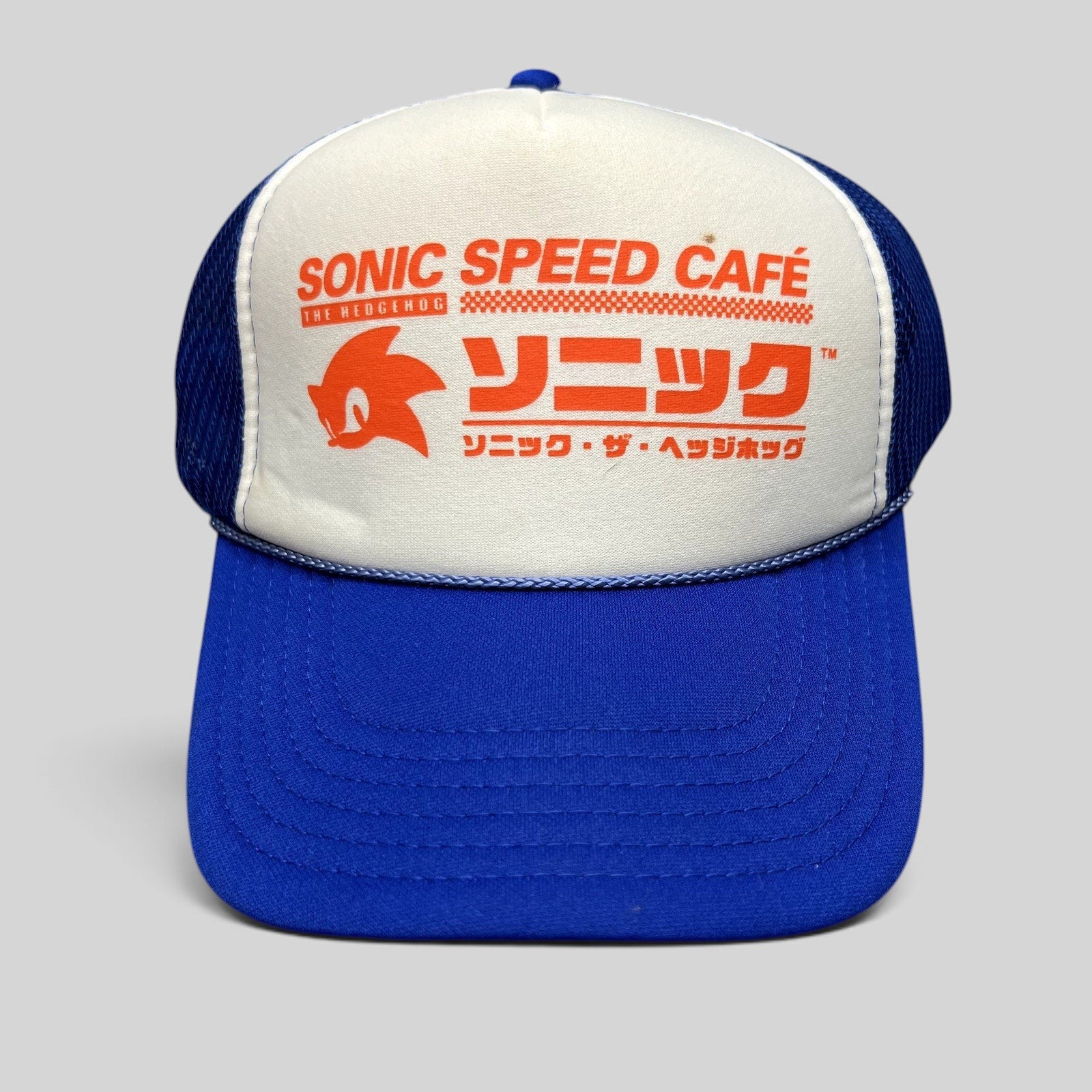 Raree Finds Sonic Speed Café trucker hat in blue and white with Japanese katakana and Sonic silhouette graphic.