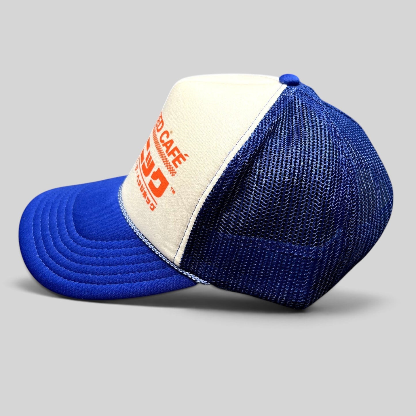 Raree Finds Sonic Speed Café trucker hat in blue and white with Japanese katakana text and mesh back panels.