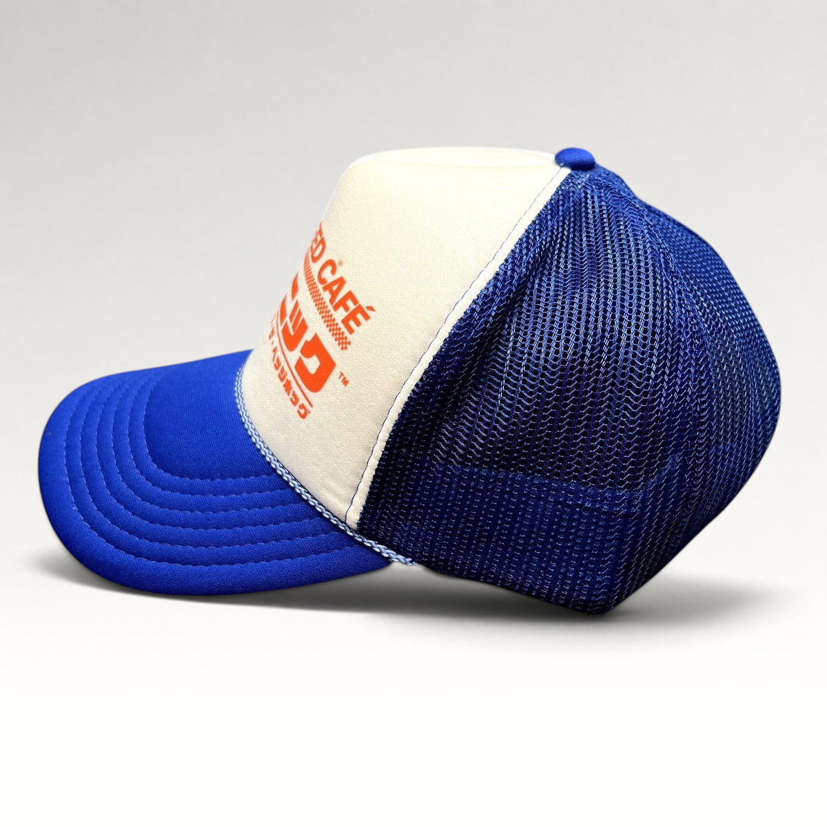 Raree Finds Sonic Speed Café trucker hat in blue and white with Japanese katakana text and mesh back panels.