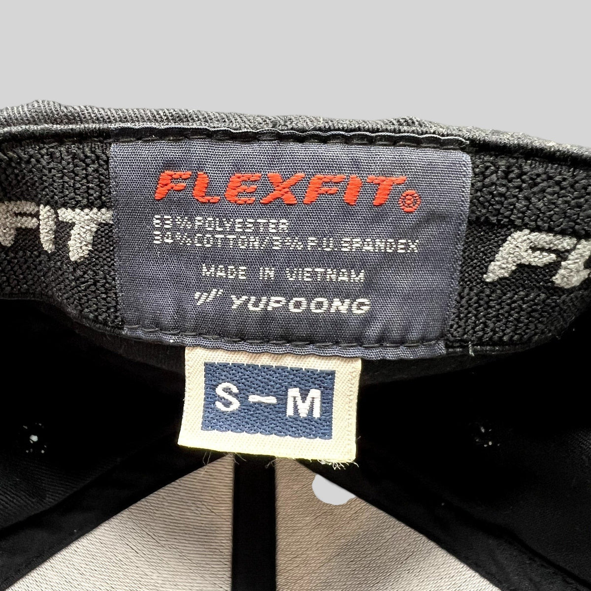 Raree Finds SpaceX Falcon Heavy hat interior label showing Yupoong Flexfit branding and size S/M tag