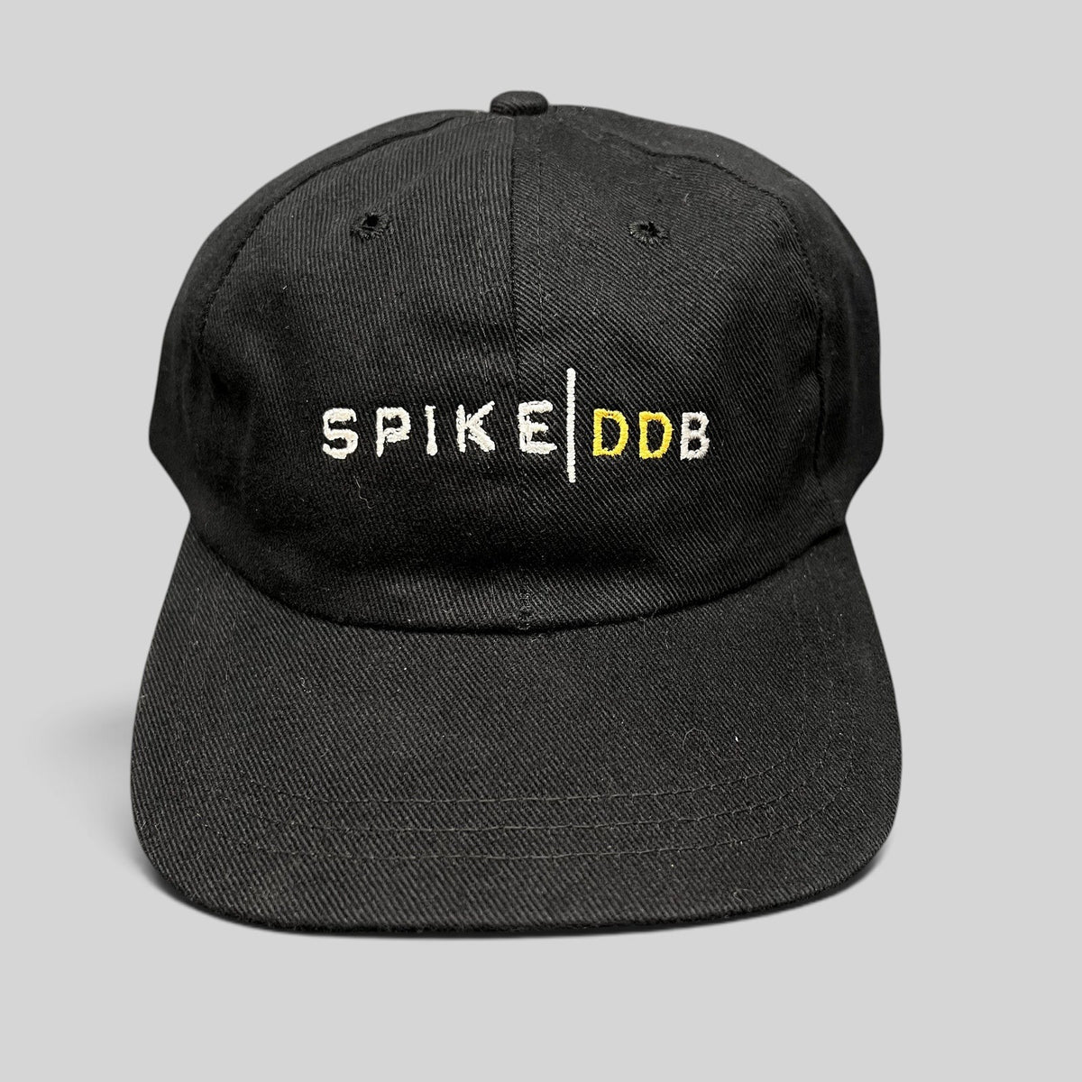 Raree Finds vintage black brushed cotton strapback hat with white and gold embroidered Spike DDB creative agency logo