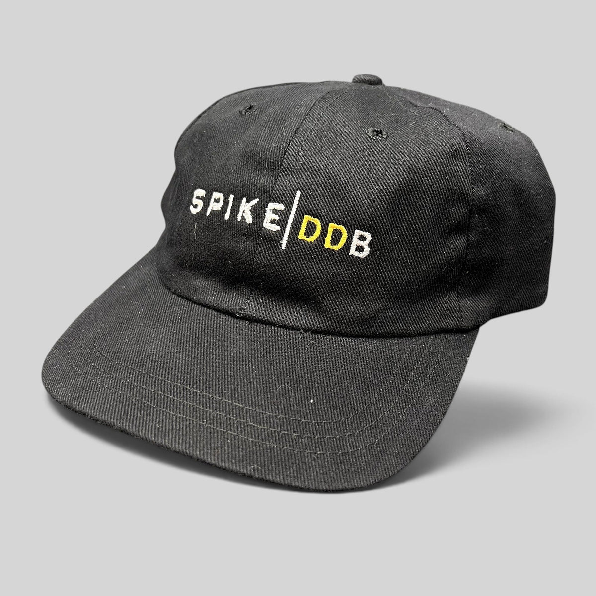 Raree Finds vintage black brushed cotton strapback hat with white and gold embroidered SPIKE DDB creative agency logo