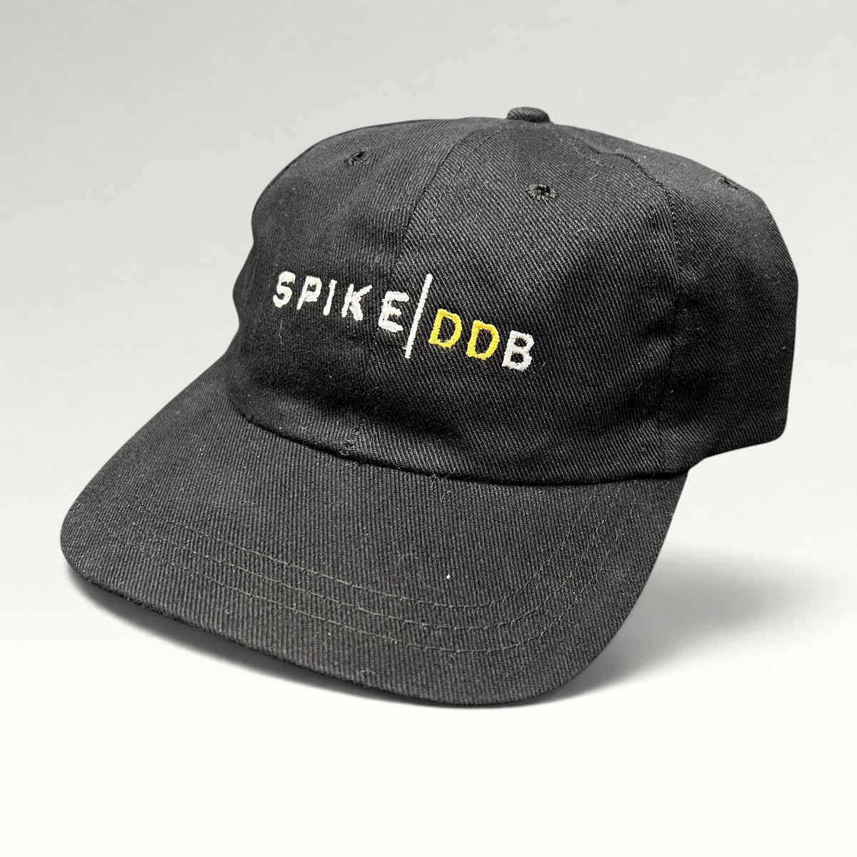 Raree Finds vintage black brushed cotton strapback hat featuring white and gold embroidered SPIKE | DDB agency logo.