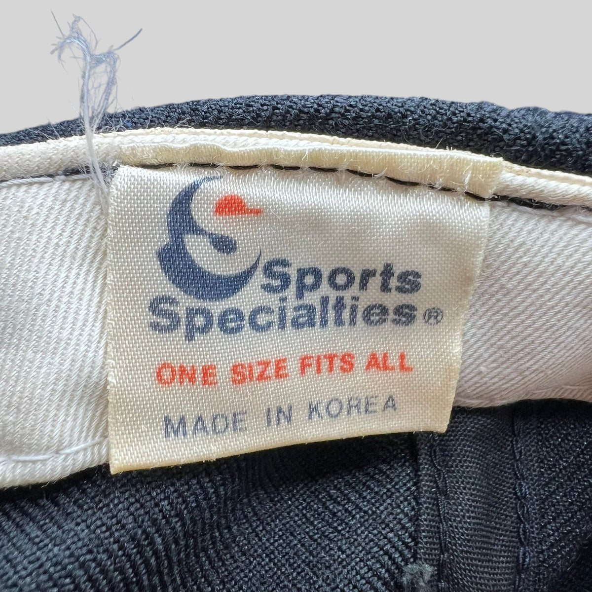 Raree Finds vintage Sports Specialties cap interior label showing brand logo, one size fits all, and made in Korea