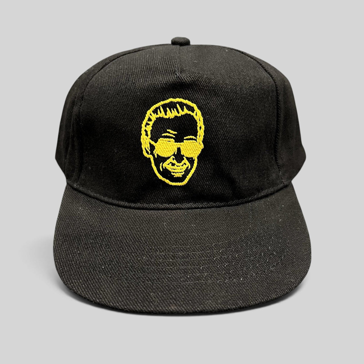 Raree Finds black strapback hat featuring gold embroidered Stan Lee portrait from 2019 Riyadh SuperCon event.