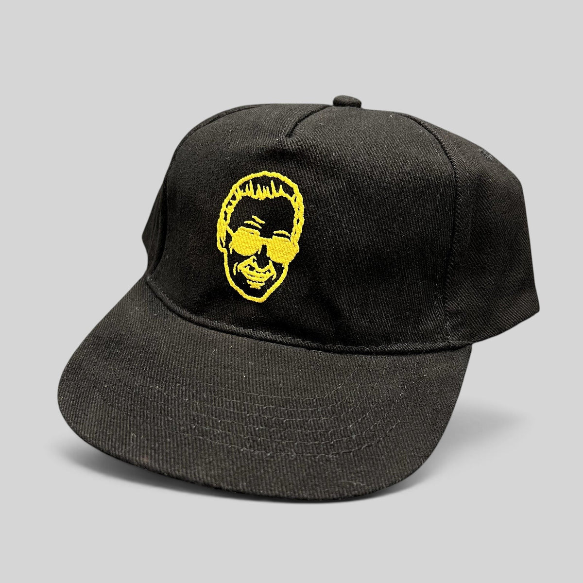 Raree Finds black strapback hat featuring gold embroidered Stan Lee portrait from 2019 Riyadh SuperCon event.