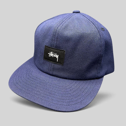 Raree Finds navy Stussy strapback hat with a minimalist black box logo patch and white script embroidery
