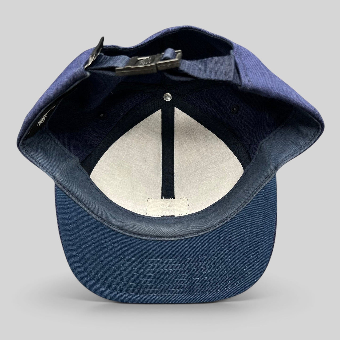 Raree Finds navy Stussy strapback hat interior view showing adjustable strap closure and structured crown construction