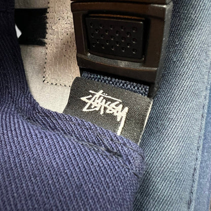 Raree Finds navy Stussy strapback hat featuring a black interior fabric tag with white signature script logo