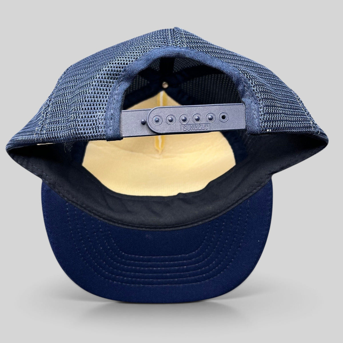 Raree Finds vintage Sunbelt trucker hat back view showing navy mesh, adjustable snapback closure, and navy brim.
