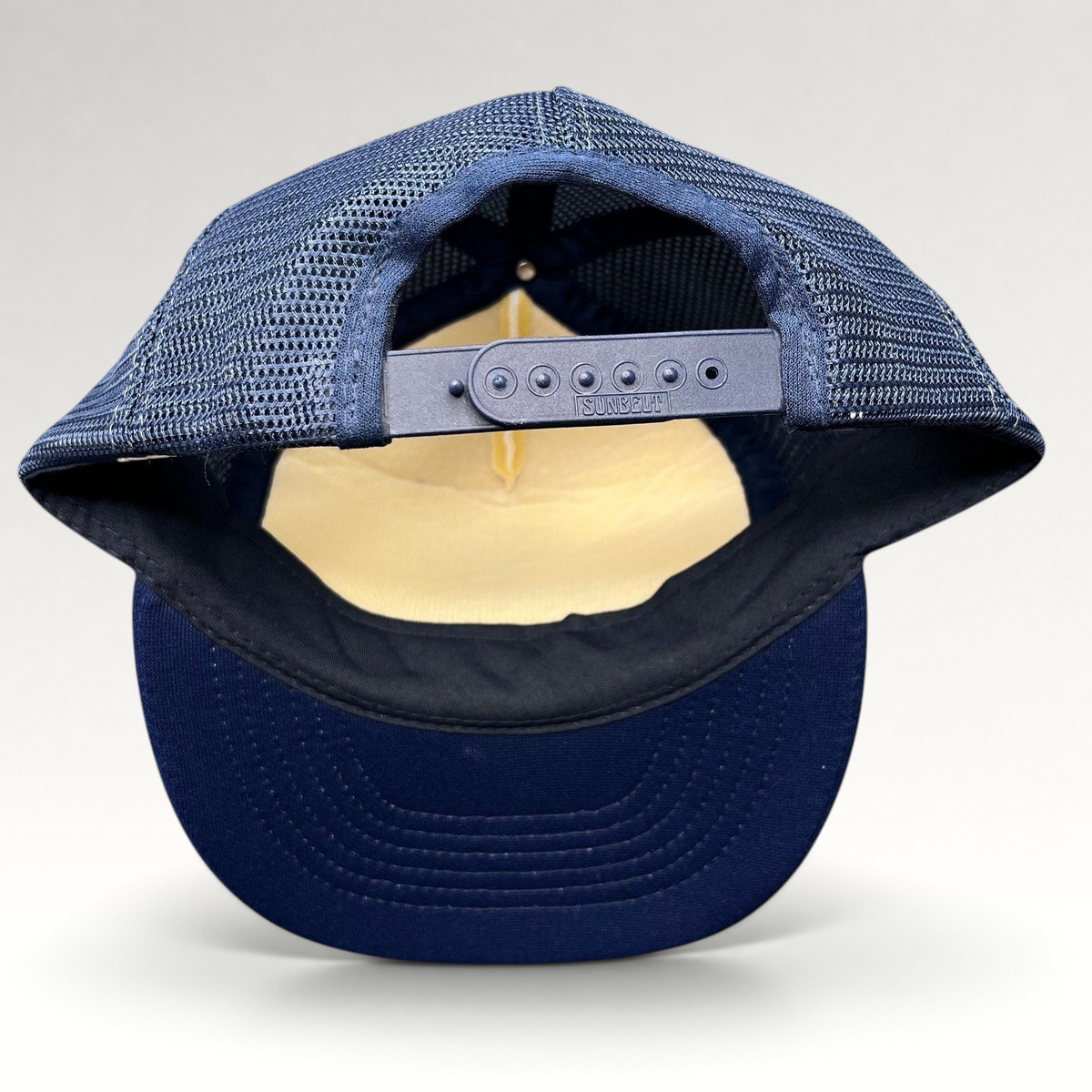Raree Finds vintage Sunbelt trucker hat back view showing navy mesh, adjustable snapback closure, and navy brim.