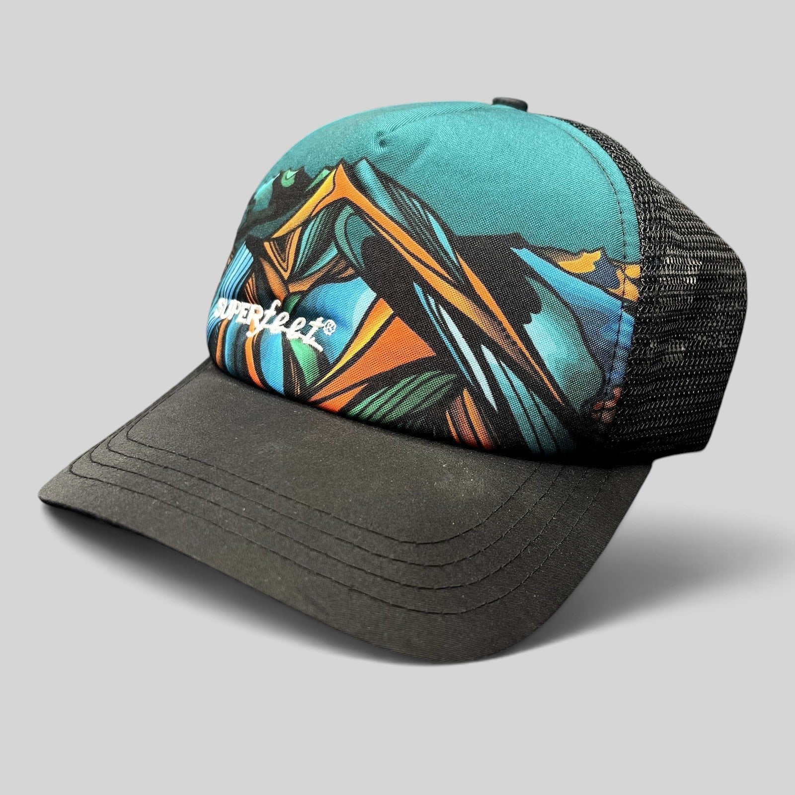 Raree Finds Superfeet GoPro Mountain Games trucker hat with colorful abstract mountain graphic and black mesh back.