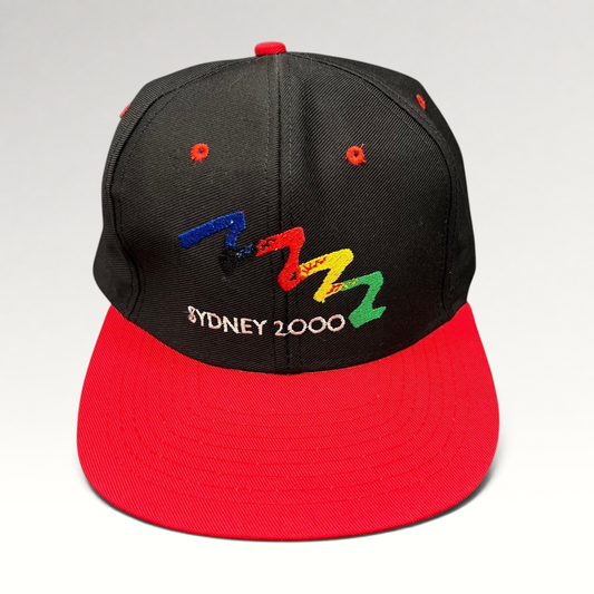 Raree Finds vintage Sydney 2000 Olympics snapback hat with black crown, red brim, and multicolor embroidered logo.