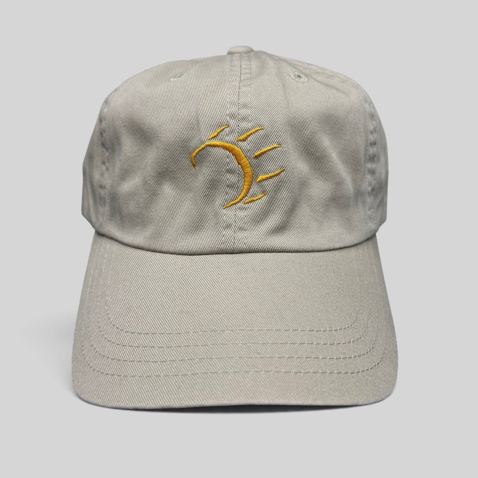 Raree Finds vintage tan cotton strapback hat with a minimalist gold embroidered dancing bear graphic on the front.
