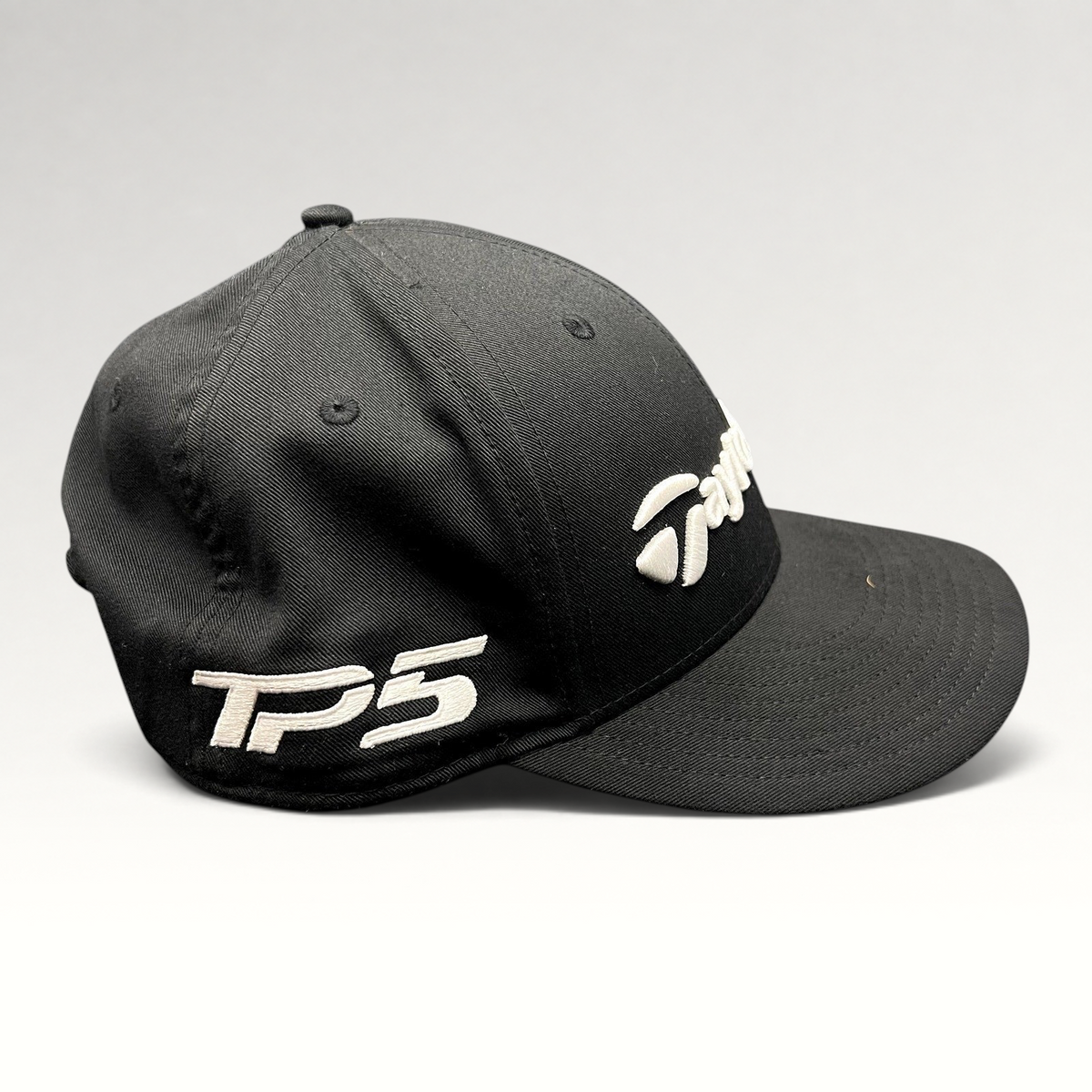 Raree Finds black TaylorMade TP5 golf snapback hat with raised white embroidery on the front and side panels.
