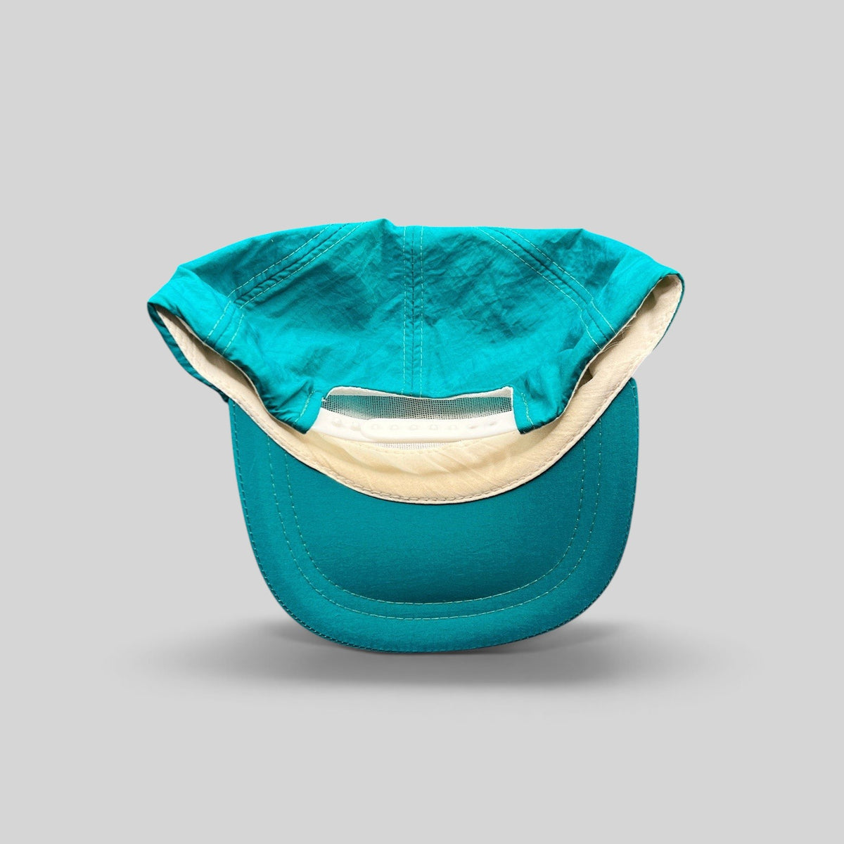 Raree Finds vintage 1992 Aspen Air Show teal nylon snapback hat showing the interior mesh and adjustable plastic strap