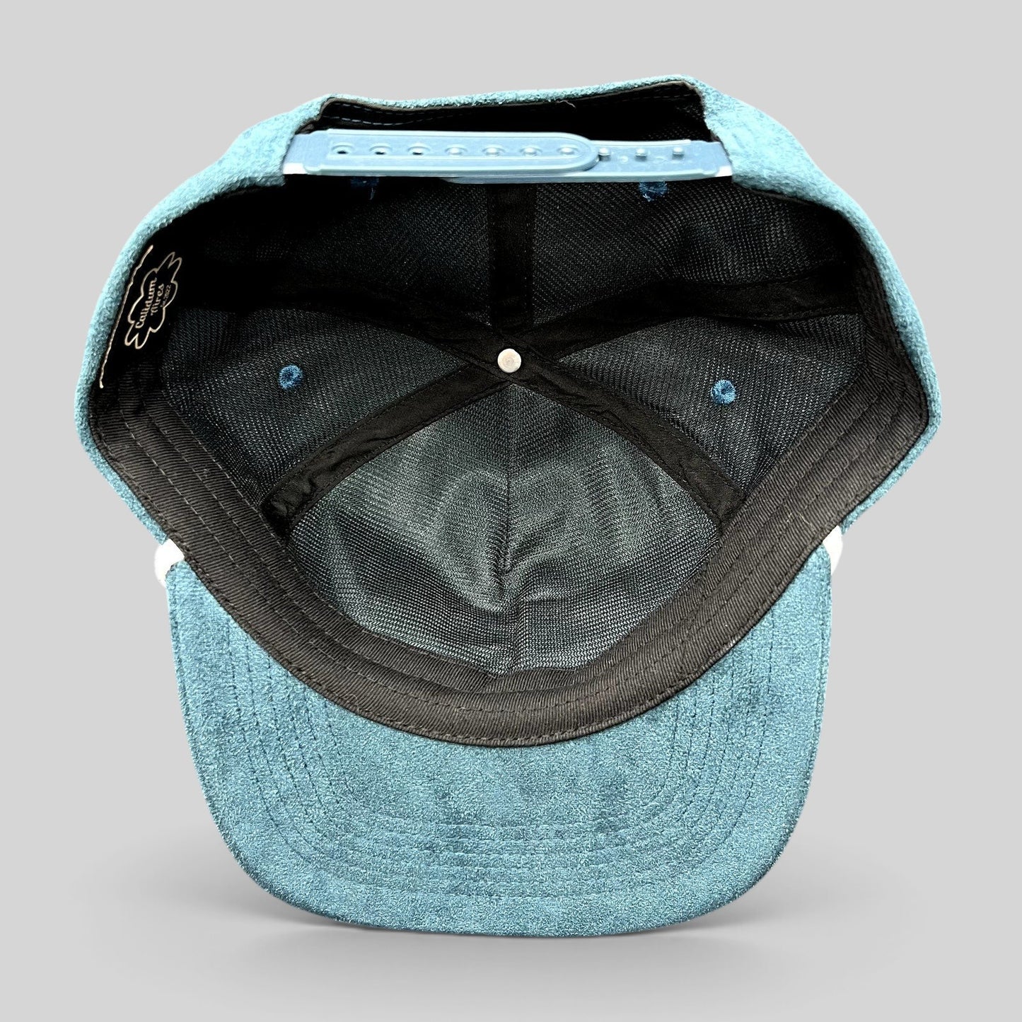 Raree Finds Calidum Aires teal suede snapback hat interior view showing black mesh lining and adjustable closure