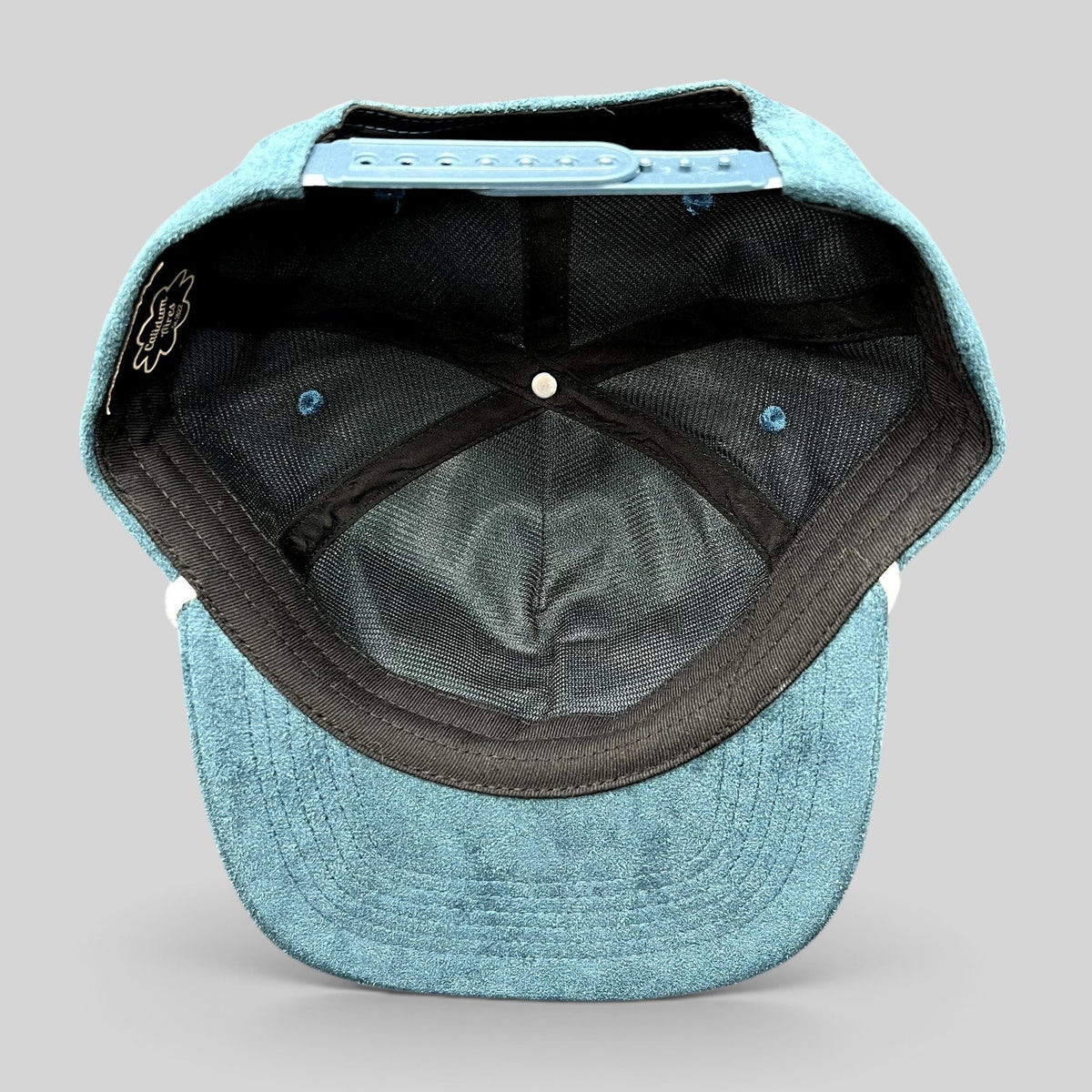 Raree Finds Calidum Aires teal suede snapback hat interior view showing black mesh lining and adjustable closure