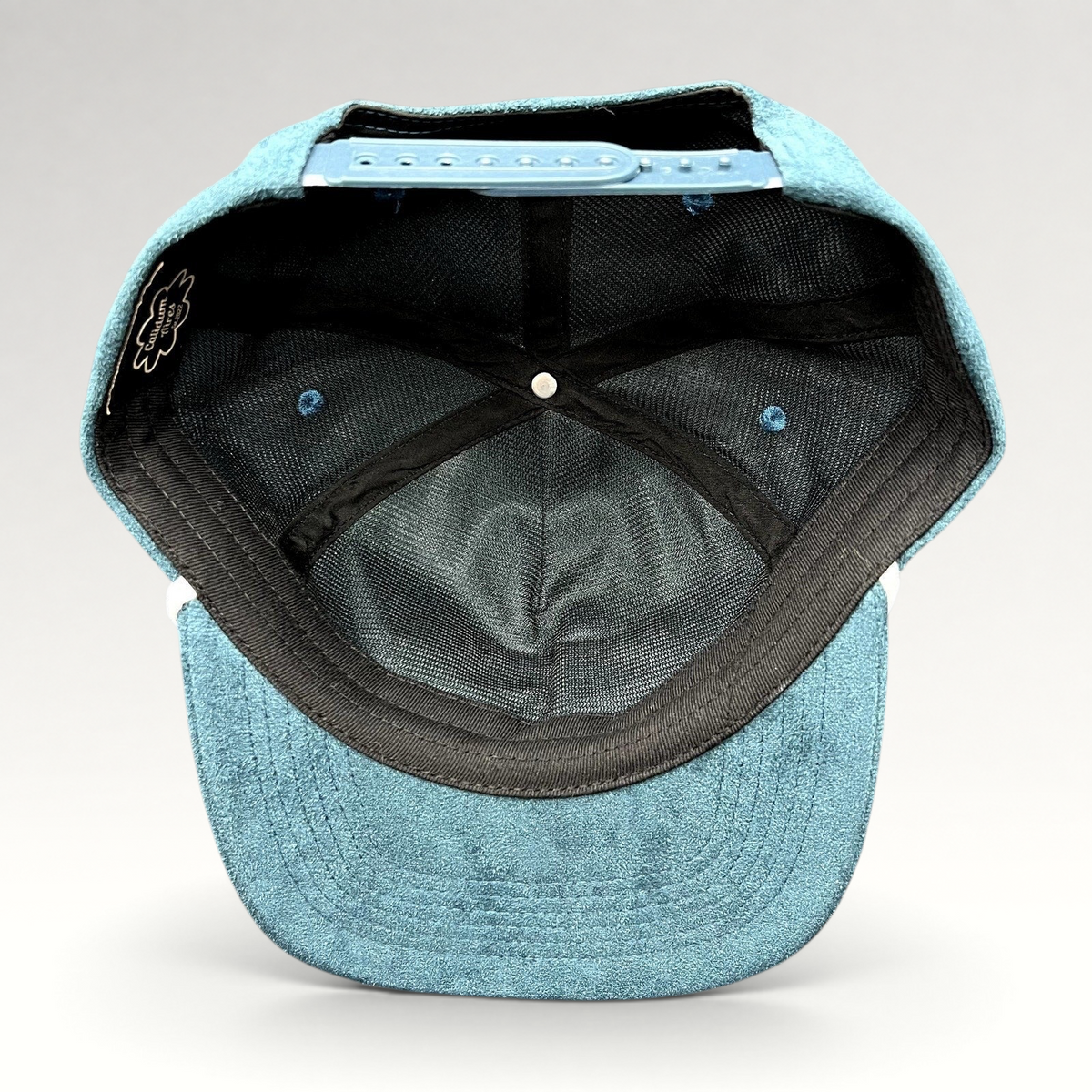 Raree Finds Calidum Aires teal suede snapback hat interior view showing black mesh lining and adjustable closure