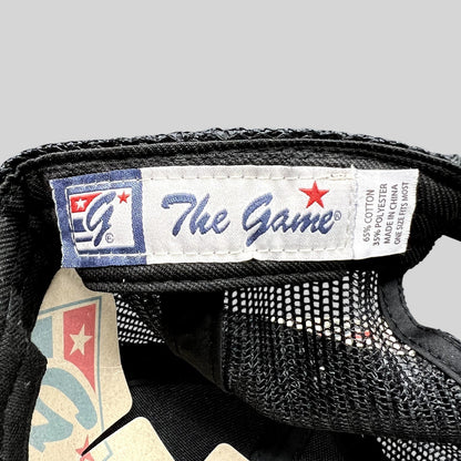 Raree Finds The Game brand interior label on a black mesh trucker hat with cotton and polyester fabric details